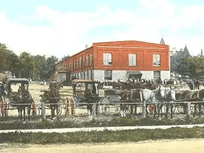 old painted photo of the kitchener market with a building in background and horse and buggies in the foreground