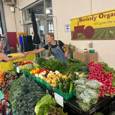 Vendor selling produce to a customer at the Kitchener Market 