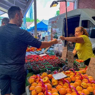 Patron purchasing fresh fruit from a vendor