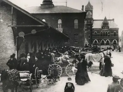 old black and white photo of horse and buggies outside of a farmers market in the 1830s