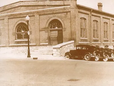 Photo from 1907 of Kitchener Market building with cars parked outside